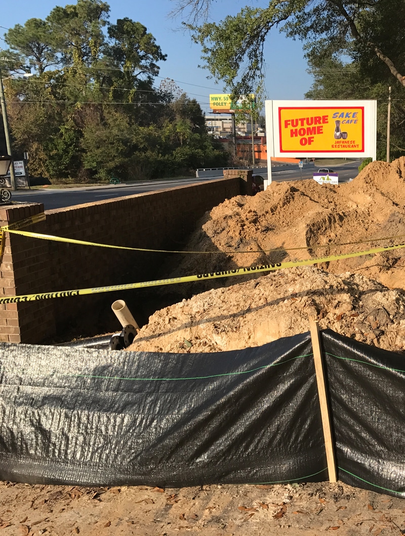 A large hole being dug on the side of the road in compliance with the Stormwater Training Center's Construction SWPPP certifications