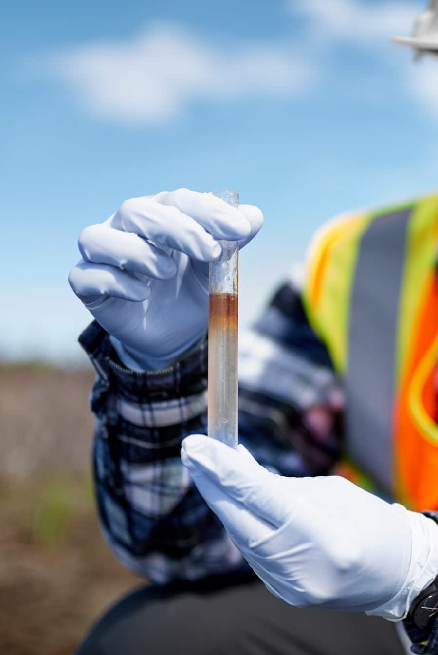 Person holding a stormwater sample in a test tube as a part of the Stormwater Training Center's Impaired Waters and TMDL Program