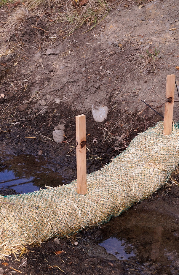 Compacted hay in netting stopping the flow of water in a light stream